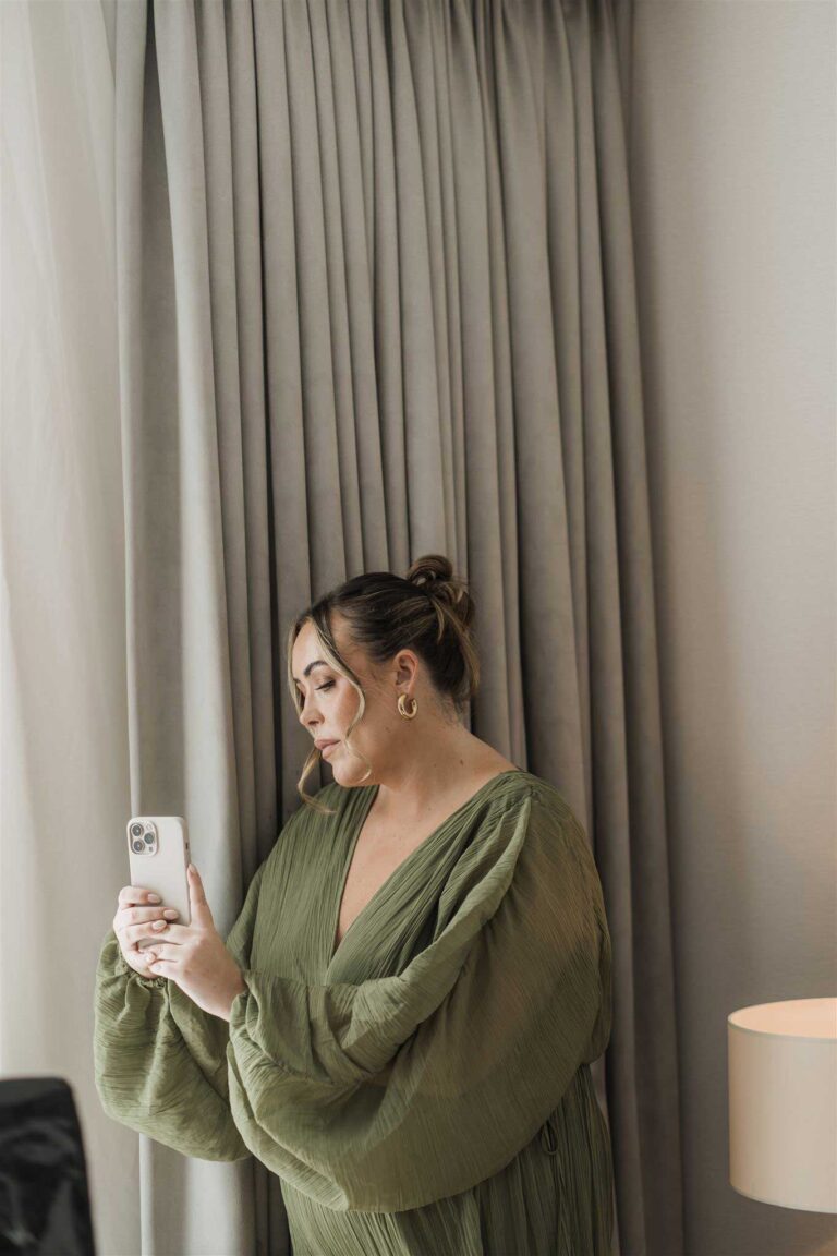 A woman holds her phone, showing the latest trend for Content Creators At Weddings