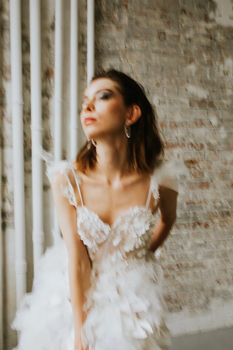 A model in a textured wedding dress leans forward in this image with motion blur to illustrate and article on being ghosted by a client as a wedding photographer