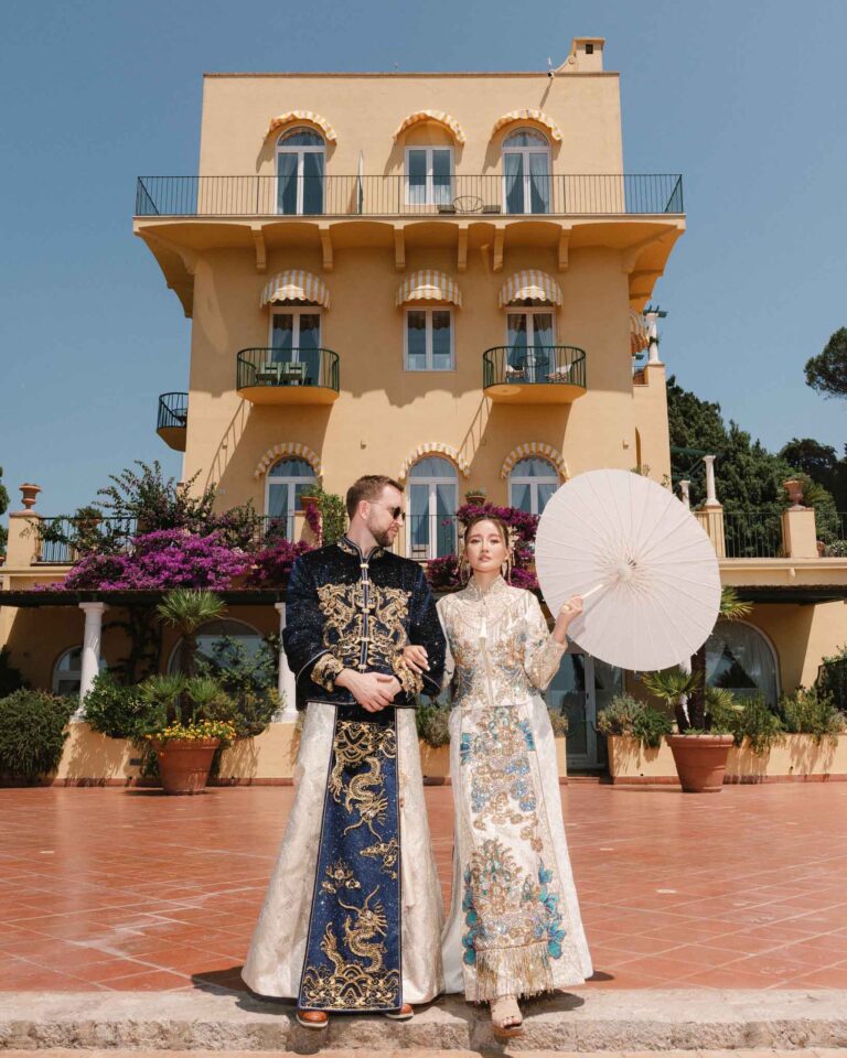 A bride and groom pose for portraits in traditional outfits for multi cultural, Fashion-Forward Destination Wedding Photography.