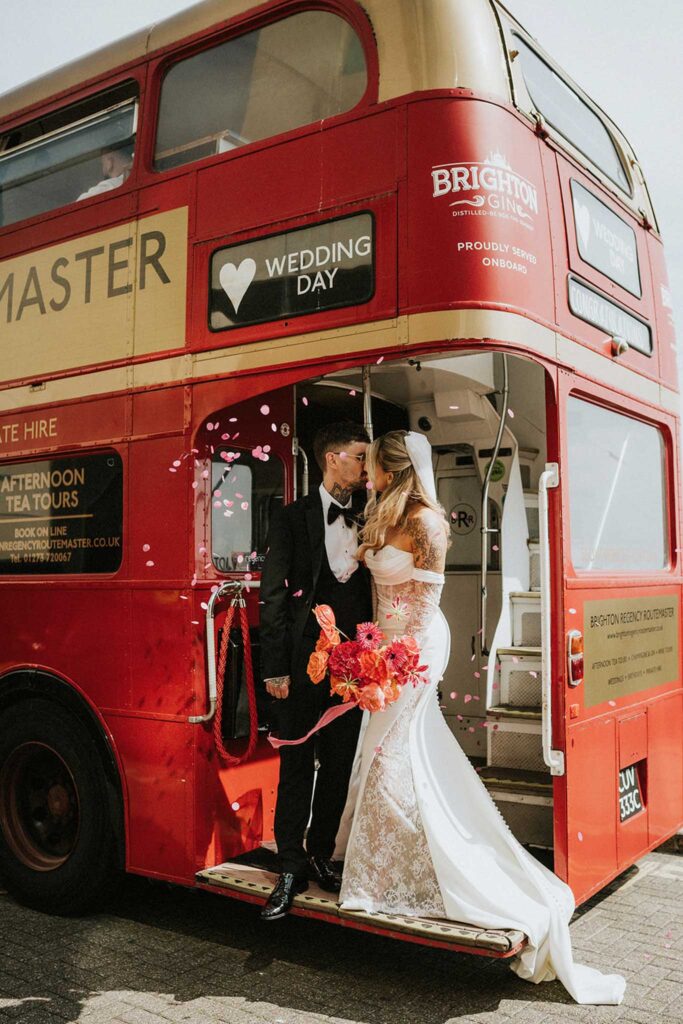 A bride and groom share a kiss beside a vintage red double-decker bus decorated for their wedding day.
The perfect photo to go with a blog about Offboarding Process For Wedding Photographers.