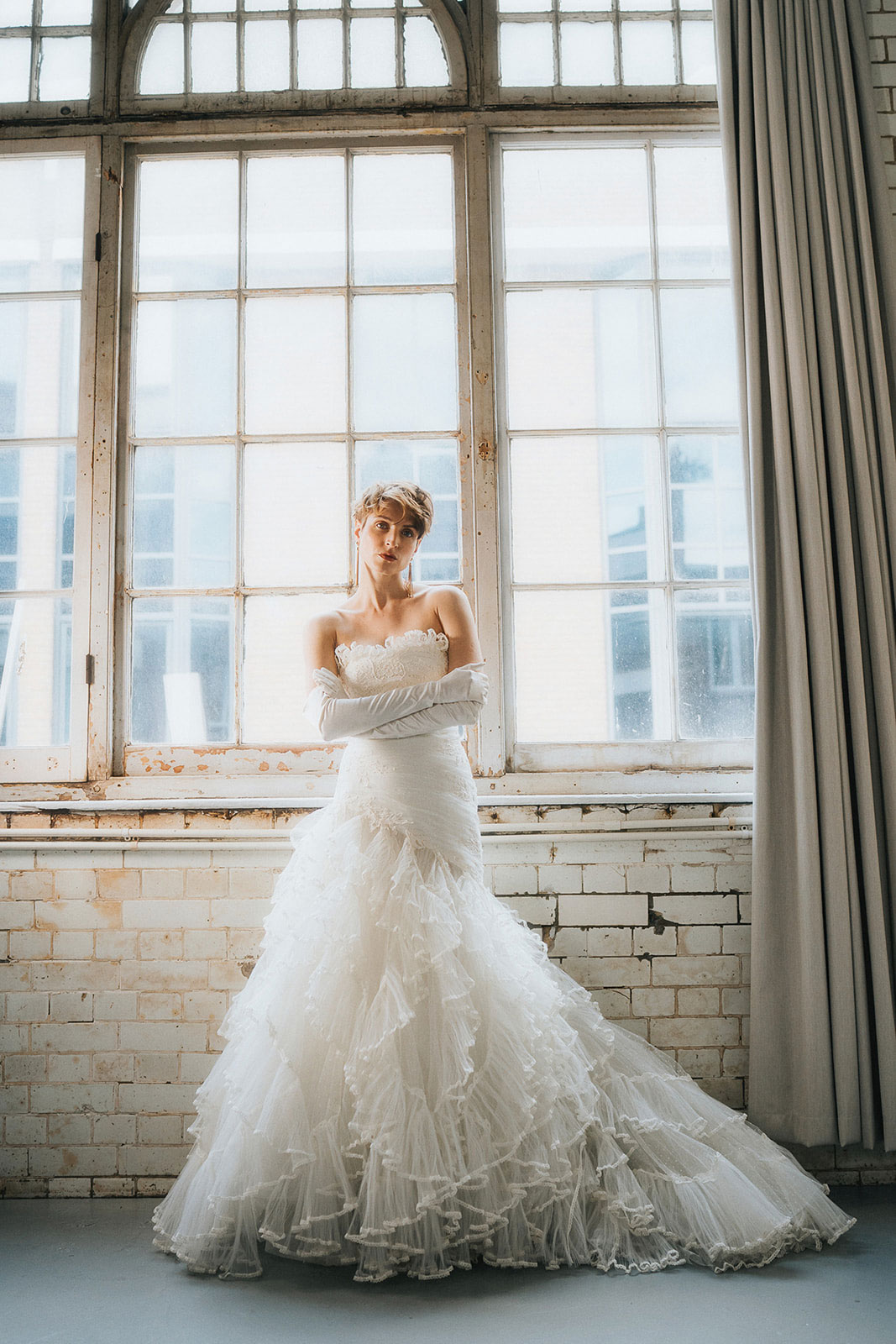 A model poses in a stunning bridal gown in an urban warehouse, a great photo to go with a blog on defining your ideal photographer.