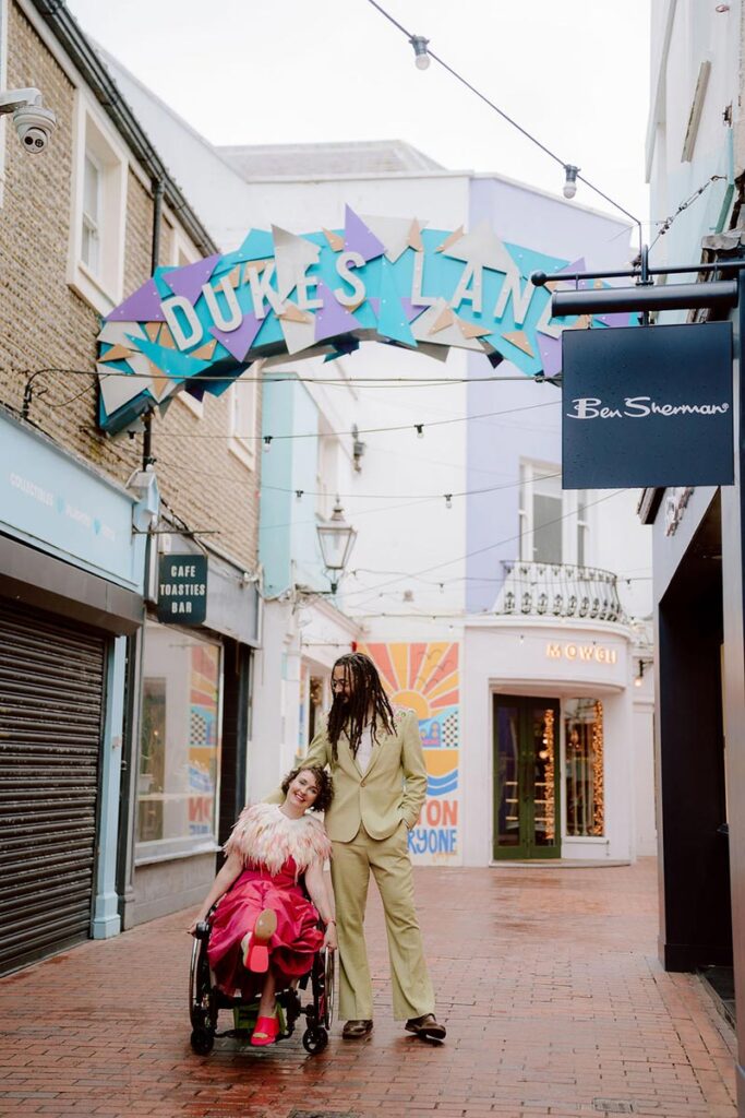 Meg and Xander under the colourful Duke’s Lane sign in Brighton during Kim Williams’ Thrive workshop shoot, showing creative post-Town-Hall wedding photography in the city centre.
